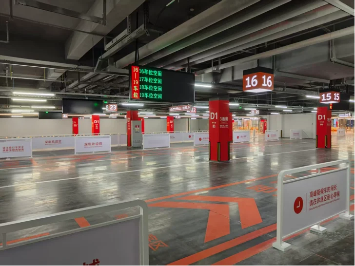 Ride-hailing vehicles parked in assigned bays at the B3 pickup zone of Shenzhen's Huanggang Port